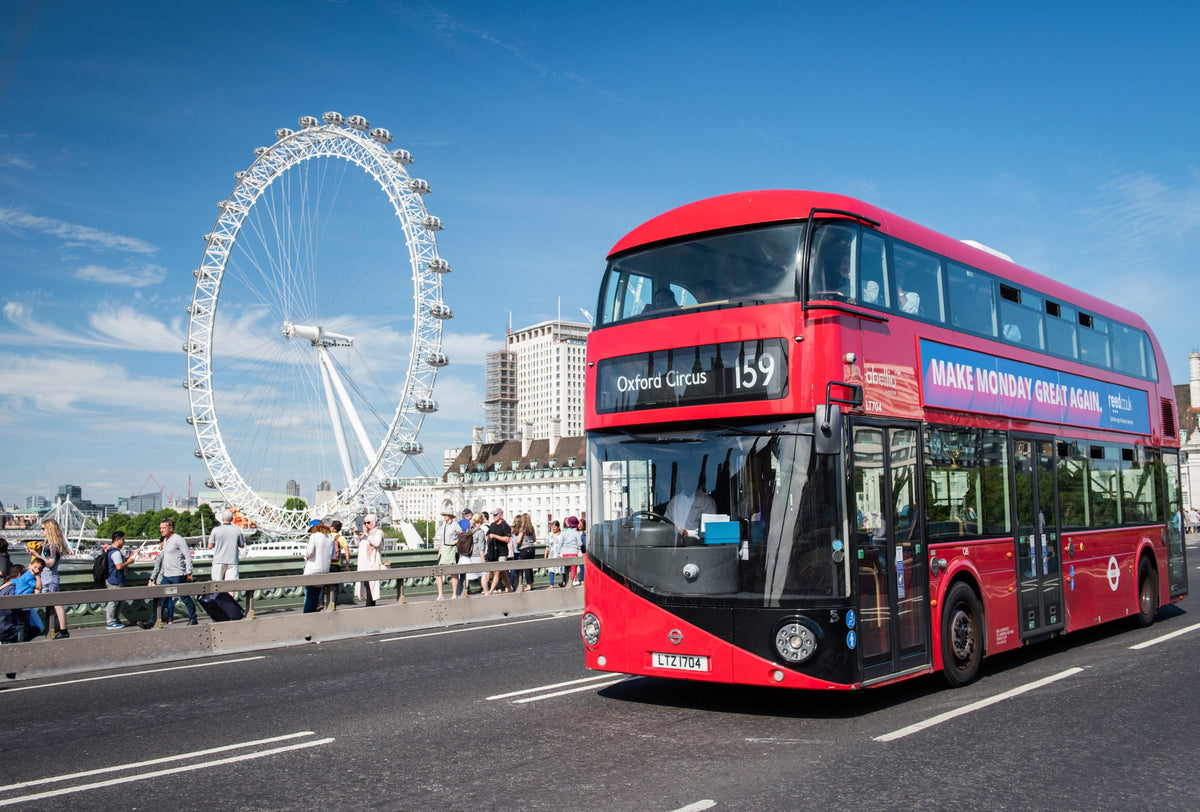 Red double-decker bus on Westminster Bridge with the London Eye behind